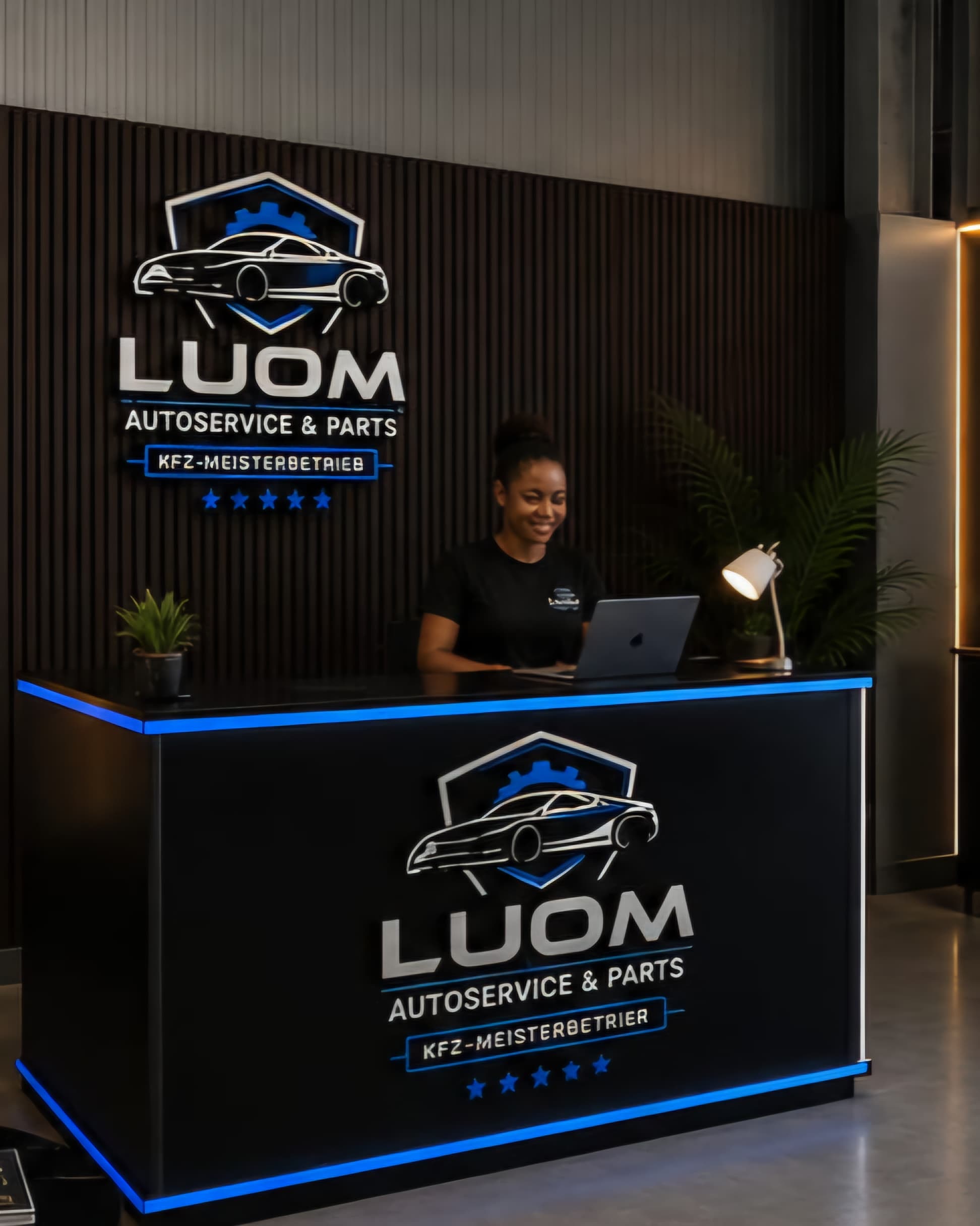 Frau am modernen Empfangstresen von LUOM Autoservice & Parts arbeitet konzentriert an einem Laptop.